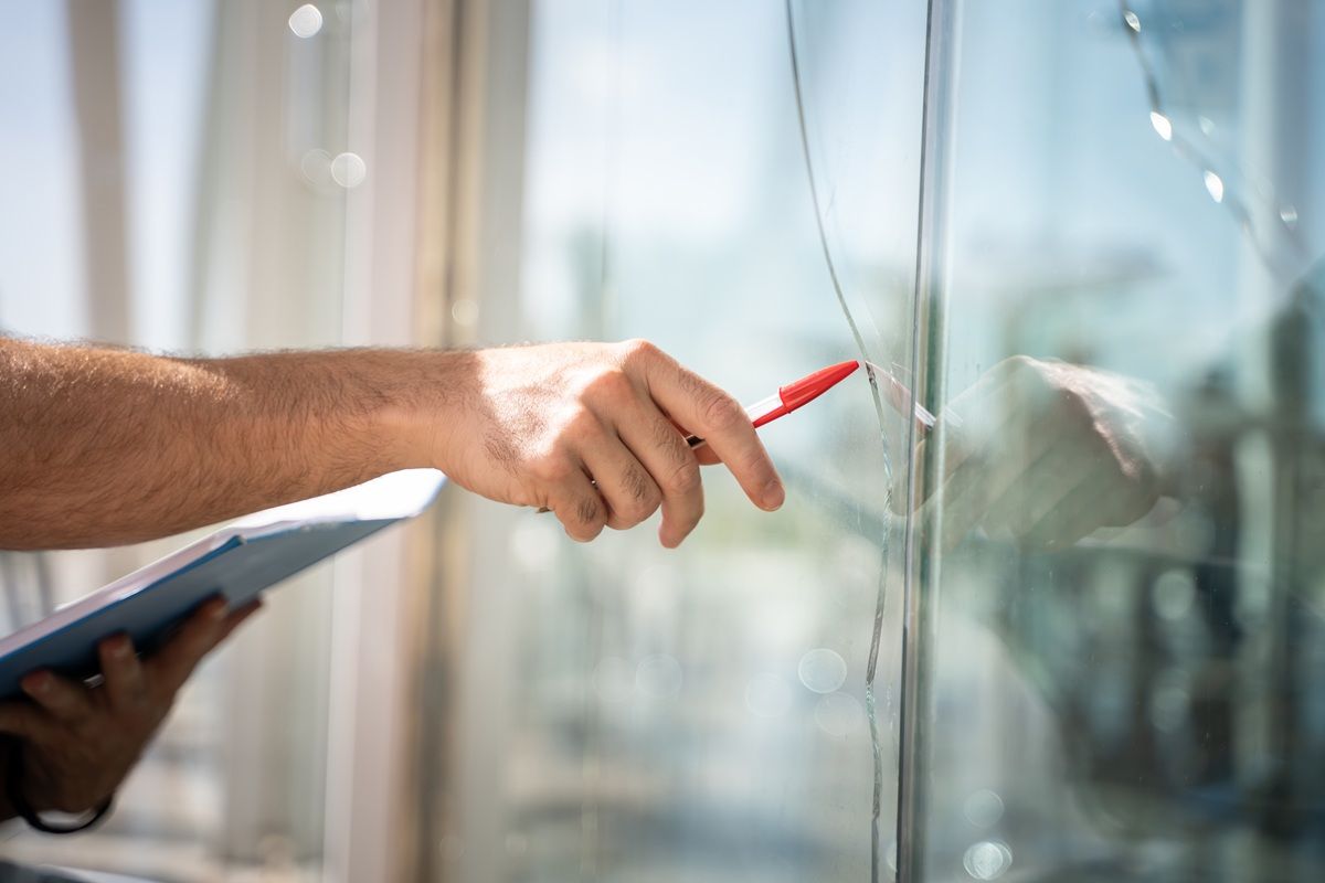 A cracked window being inspected, the sign it is time to replace it