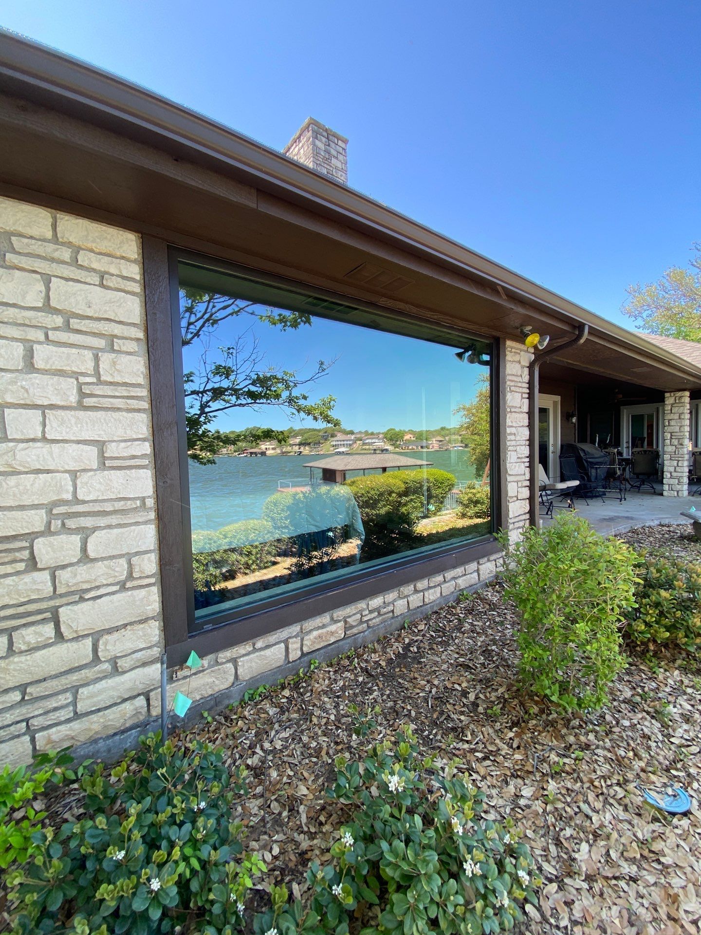 Big picture window on a stone home by the lake
